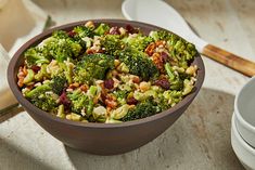 a bowl filled with broccoli and nuts on top of a table