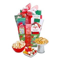 a christmas gift basket filled with sweets and treats next to a bowl of candy,