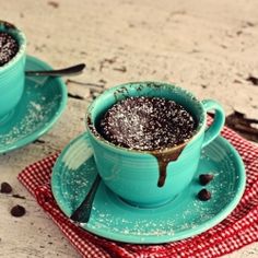 two blue cups filled with chocolate pudding on top of a table