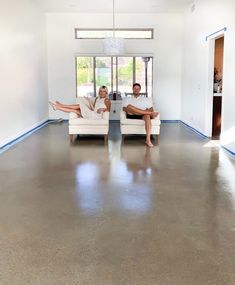 two people sitting on chairs in an empty room