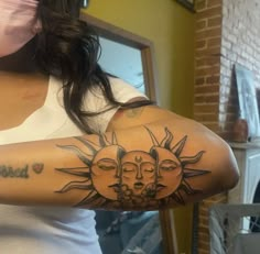 a woman with a sun and moon tattoo on her arm