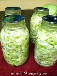 three jars filled with cabbage sitting on top of a table