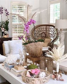 a living room filled with lots of furniture and flowers on top of a white table