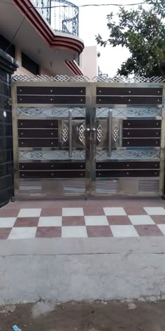 an entrance to a building with two gates and checkered flooring on the ground