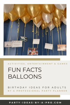 balloons are hanging from the ceiling in front of a blue wall with white and gold foil