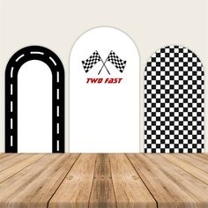 two fast racing flags on the wall next to a wooden table with an arched window