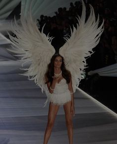 a model walks down the runway in an angel costume