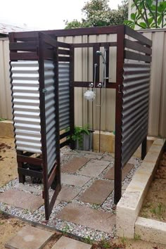 an outdoor shower is shown in the middle of a yard with gravel and rocks around it