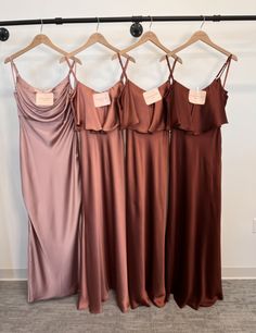 three bridesmaid dresses hanging on a rack