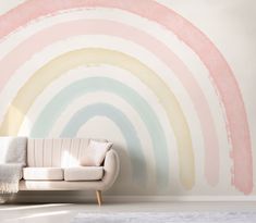 a white couch sitting in front of a wall painted with pastel rainbows on it