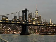 the city skyline is lit up at night as seen from across the water in new york