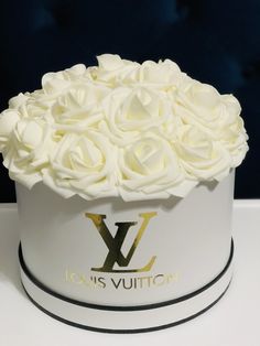 a white hat with roses in it sitting on a table