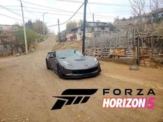 a black sports car driving down a dirt road