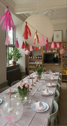 the table is set with pink and white decorations