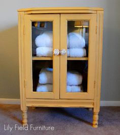 a yellow cabinet with towels stacked on top