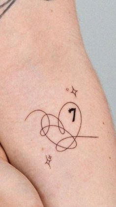 a woman's arm with a tattoo on it that has the number one and stars