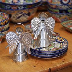 silver angel figurines sitting on top of plates