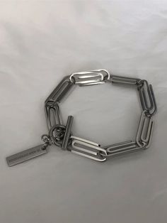 a stainless steel bracelet with an id tag on the clasp and a chain attached to it