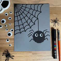 an image of a spider on a sheet of paper next to some markers and pens