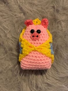 a crocheted cell phone case with a pink and yellow bear on it's back