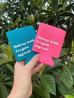 two pink and blue coasters that say hold my drink i've gota dog to pet