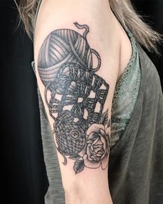 a woman's arm with a black and white tattoo design on her left arm