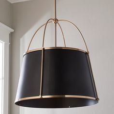 a black and gold chandelier hanging from a ceiling in a room with white walls