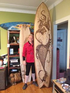 a woman standing next to two surfboards in a room