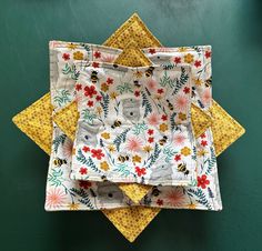 three yellow and white placemats on top of each other, with flowers printed on them