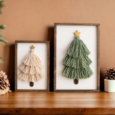 two framed christmas tree decorations on a shelf