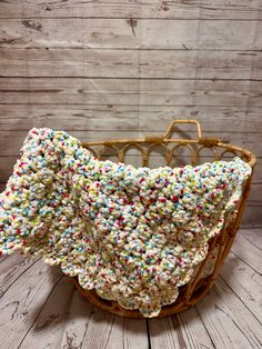 a basket with sprinkles on it sitting on a wooden floor