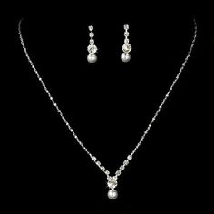 Simply stunning, this silver plated necklace and earring set features a lovely arrangement of rhinestones and white pearls. Versatile, the set is the perfect accessory to your classic or modern wedding, and coordinates beautifully with your white wedding dress. The necklace has a lobster claw clasp. Earrings has post back closure for pierced ears.   * Material: Crystals, Rhinestones, White Pearl, Shiny Metal Casting, Rhodium Plated * Dimensions (Size): Necklace: 15" Long + 3" extension (Lobster Elegant Silver Pearl Jewelry Sets, Elegant Silver Jewelry Sets With Rhinestones, Formal Silver Pearl Jewelry Sets, Silver Pearl Necklace With Rhinestones For Wedding, Silver Jewelry Sets With Pearl Drop For Formal Occasions, Elegant Silver Rhinestone And Pearl Necklace, Classic Silver Rhinestone Necklace For Wedding, Silver Crystal Pearl Necklace In Classic Style, Silver Crystal Jewelry Set With Pearl Drop