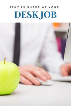 a green apple sitting on top of a white desk