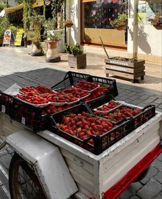 two baskets filled with strawberries sitting on the back of a bike