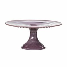 a purple cake plate sitting on top of a table