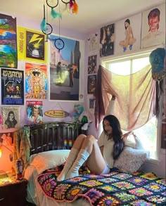 a woman sitting on top of a bed in a room filled with pictures and posters