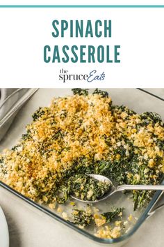 spinach casserole in a glass baking dish with spoons and utensils