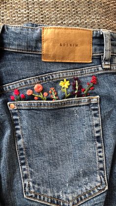 a pair of jeans with flowers in the back pocket