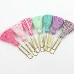 a bunch of different colored tassels sitting next to each other on a white surface