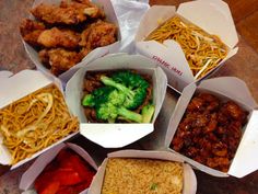 there are many different types of food in the boxes on the table, including broccoli and noodles