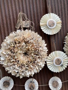 some paper flowers are hanging on a wall