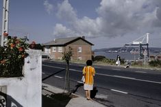 a woman standing on the side of a road