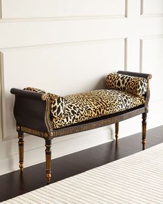 a leopard print bench sitting on top of a hard wood floor