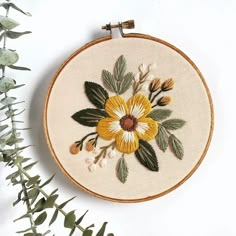 a yellow and white flower is on the embroidery