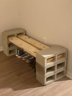 a bench made out of cinder blocks with shoes underneath