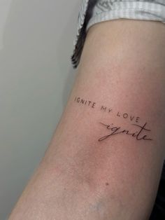 a woman's arm with the words ignite my love in cursive writing