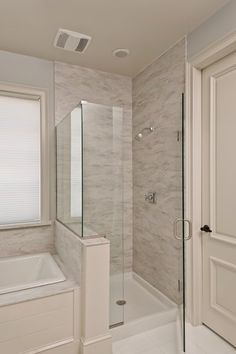 a bathroom with a walk in shower next to a bath tub