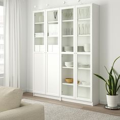 a white bookcase with glass doors in a living room