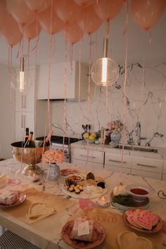 a table topped with plates and balloons filled with food