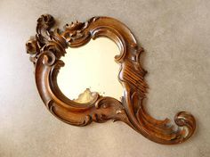 an ornate wooden mirror on the wall